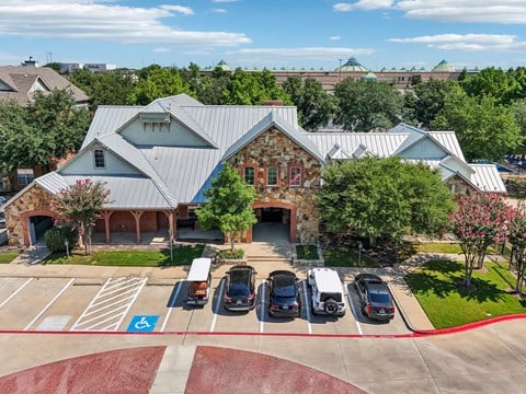 an aerial view of a parking lot with cars in front of a building